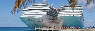 Two cruise ships docked at the pier at Grand Turk Cruise Center with turquoise water.