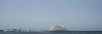 The modern white curved Porto Leixões Cruise Terminal building in Matosinhos, viewed across the water.