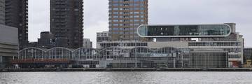 The Cruise Terminal Rotterdam building on the waterfront with modern architecture and the city skyline.