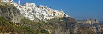 White buildings along Fira’s cliffs above the blue water of Santorini’s caldera.
